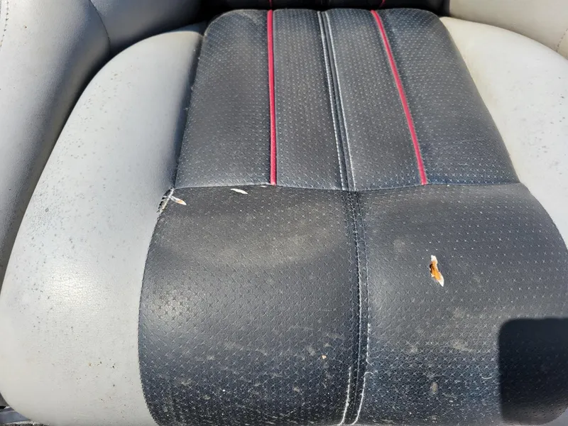 Slide: The Image of Worn seat of 2011 Ranger Z521 boat with visible tears and red stitching. - 21