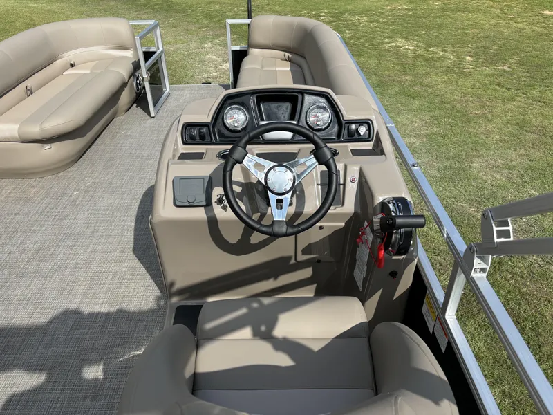 Slide: The Image of 2024 Ranger 200C boat interior with steering wheel and seating on grassy background. - 13