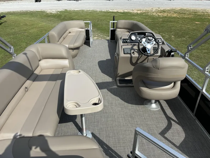Slide: The Image of 2024 Ranger 200C pontoon boat interior with beige seating and steering console. - 7