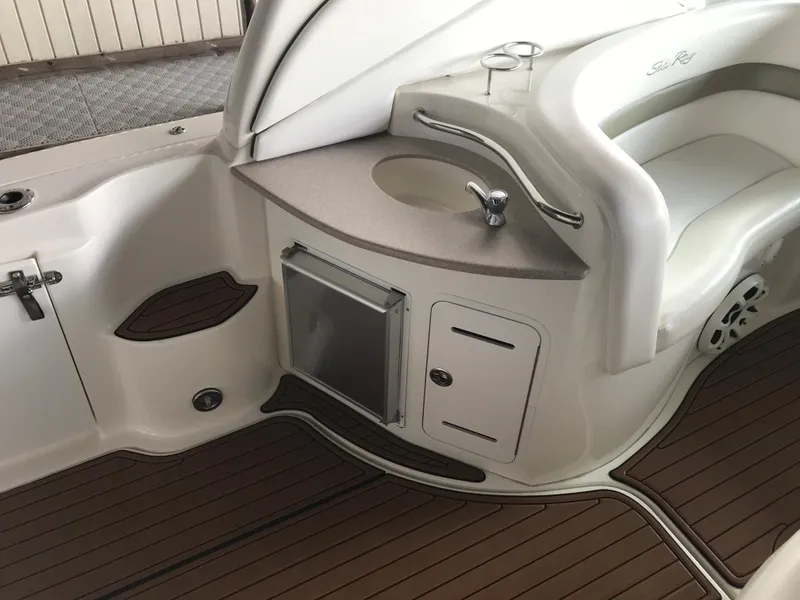Slide: The Image of 2007 Sea Ray 320 Sundancer interior with sink, storage, and seating on teak flooring. - 16