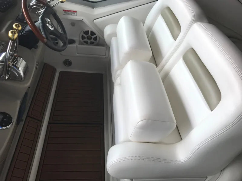 Slide: The Image of 2007 Sea Ray 320 Sundancer helm with white seating and wooden flooring. - 17