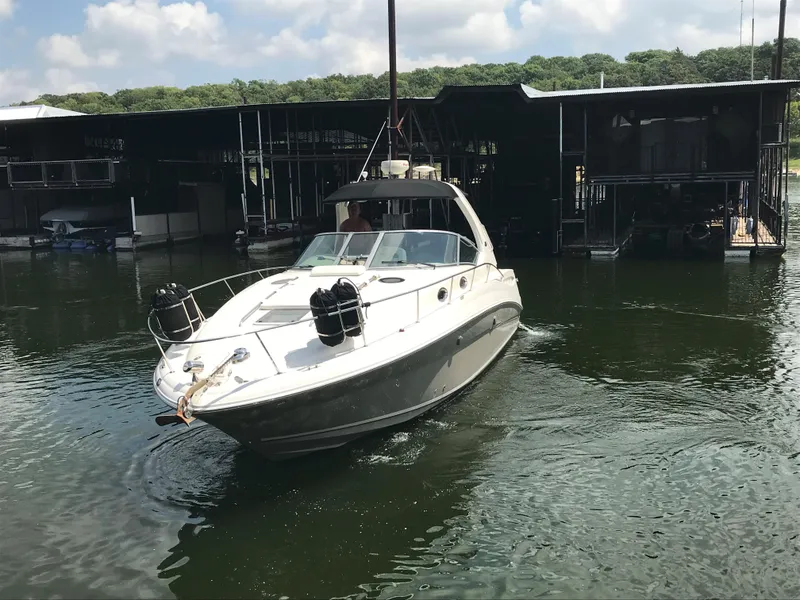 Slide: The Image of 2007 Sea Ray 320 Sundancer boat docked on a calm lake under a partly cloudy sky. - 3