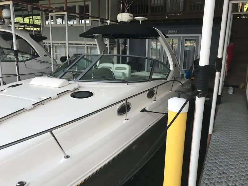 Slide: The Image of 2007 Sea Ray 320 Sundancer docked in a marina, featuring sleek design and white exterior. - 6