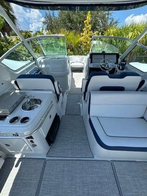 Slide: The Image of 2024 Crownline 280 DC boat interior with seating, helm, and kitchenette. - 7