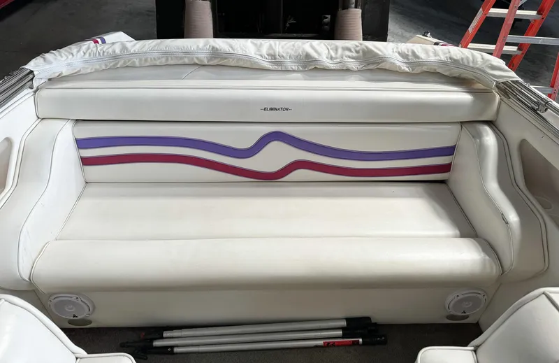 Slide: The Image of 1998 Eliminator 280 Eagle XP boat interior with white and purple-red striped seating. - 12