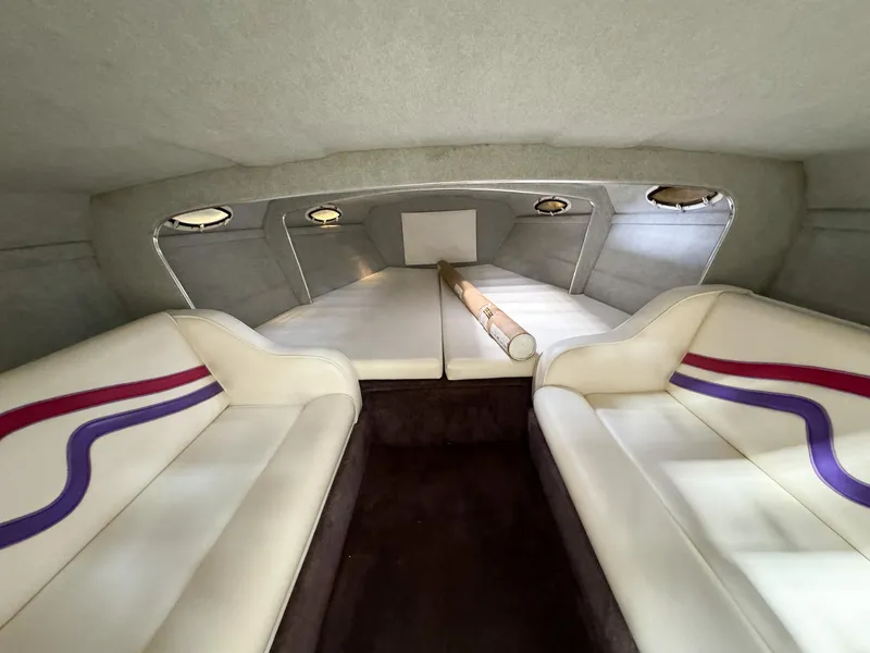 Slide: The Image of Interior cabin of a 1998 Eliminator 280 Eagle XP boat with white and purple seating. - 19