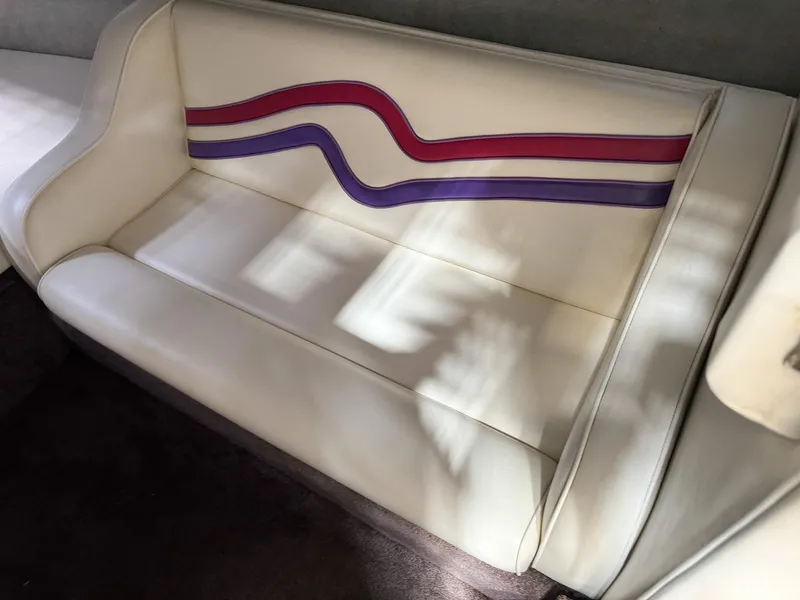 Slide: The Image of 1998 Eliminator 280 Eagle XP boat interior with white leather seating and colorful stripes. - 21
