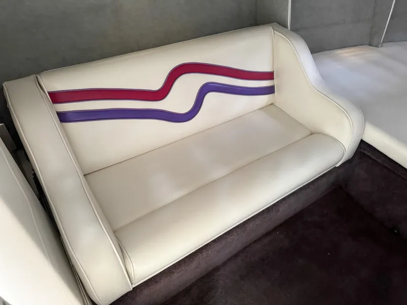 Slide: The Image of 1998 Eliminator 280 Eagle XP boat interior with white and purple-red striped seating. - 22