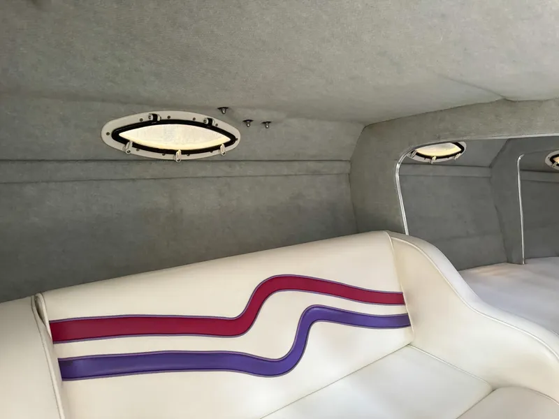 Slide: The Image of Interior of a 1998 Eliminator 280 Eagle XP boat with white and purple seating. - 23