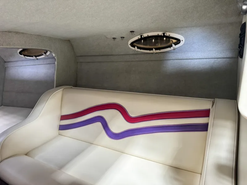 Slide: The Image of Interior of a 1998 Eliminator 280 Eagle XP boat with white and purple seating. - 25