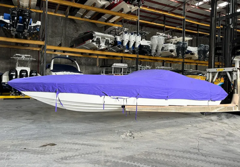 Slide: The Image of 1998 Eliminator 280 Eagle XP boat with purple cover in storage facility. - 38