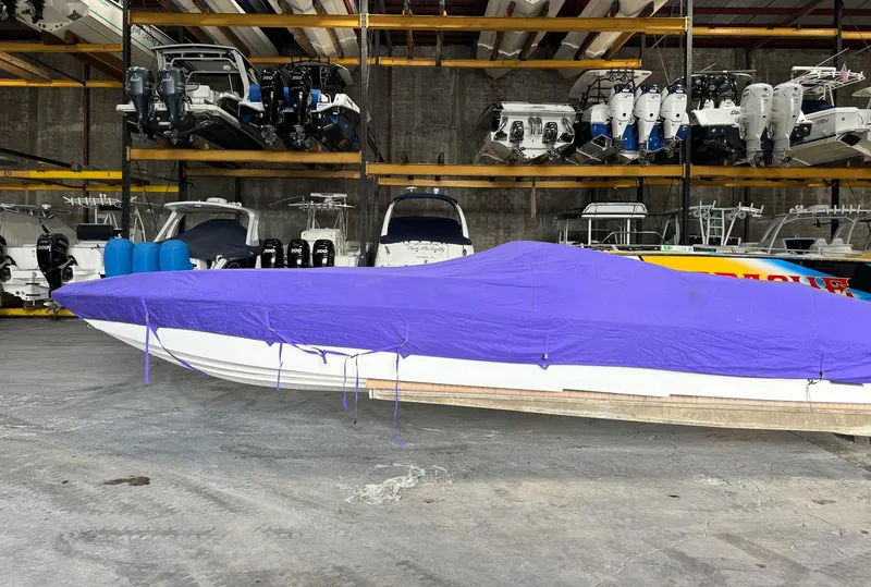 Slide: The Image of 1998 Eliminator 280 Eagle XP boat with purple cover in indoor storage. - 39