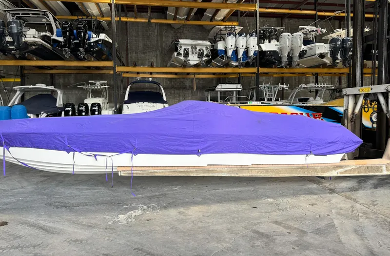 Slide: The Image of 1998 Eliminator 280 Eagle XP boat with purple cover in storage facility. - 40