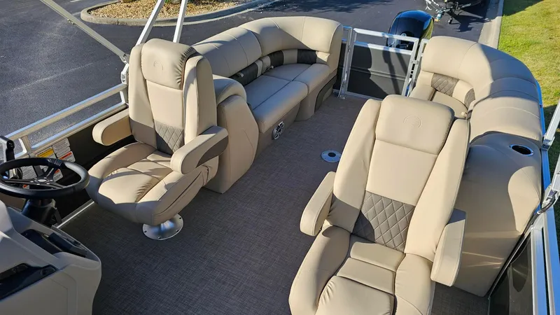 Slide: The Image of 2024 Sun Tracker Party Barge 24 DLX interior with plush seating and steering console. - 4