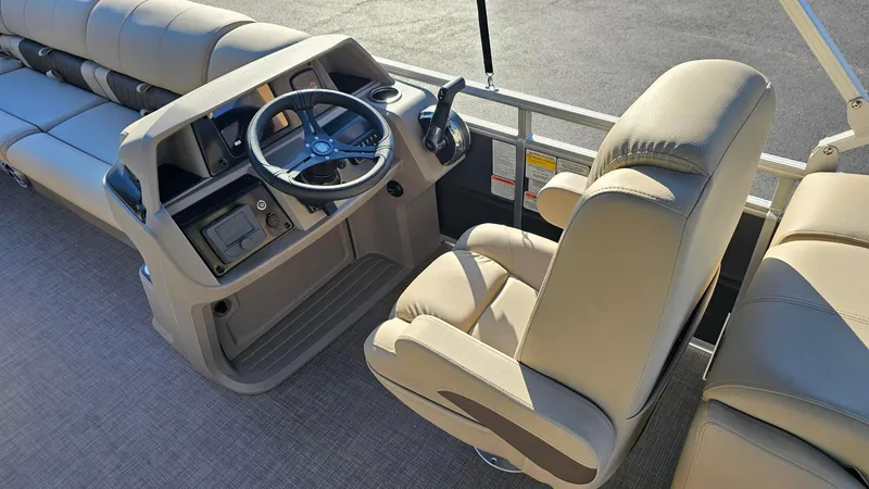 Slide: The Image of 2024 Sun Tracker Party Barge 24 DLX helm with beige captain's chair and steering console. - 5