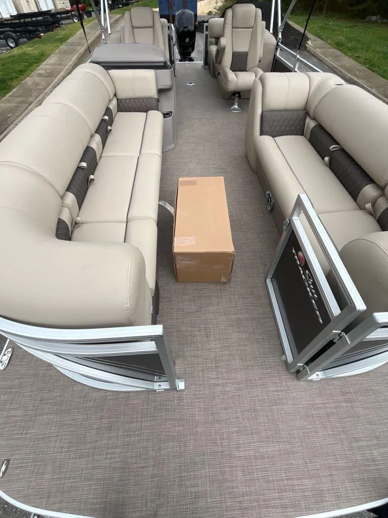 Slide: The Image of 2024 Sun Tracker Party Barge 24 DLX pontoon boat with canopy, parked on trailer. - 2