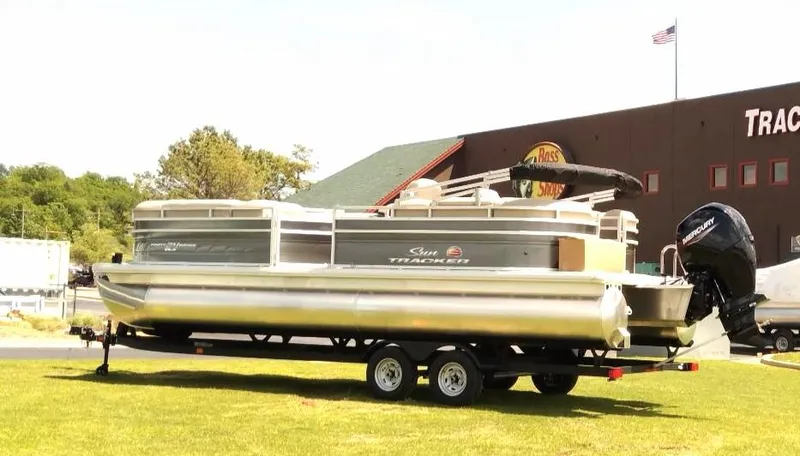 Slide: The Image of 2024 Sun Tracker Party Barge 24 DLX pontoon boat on trailer, parked outdoors. - 5