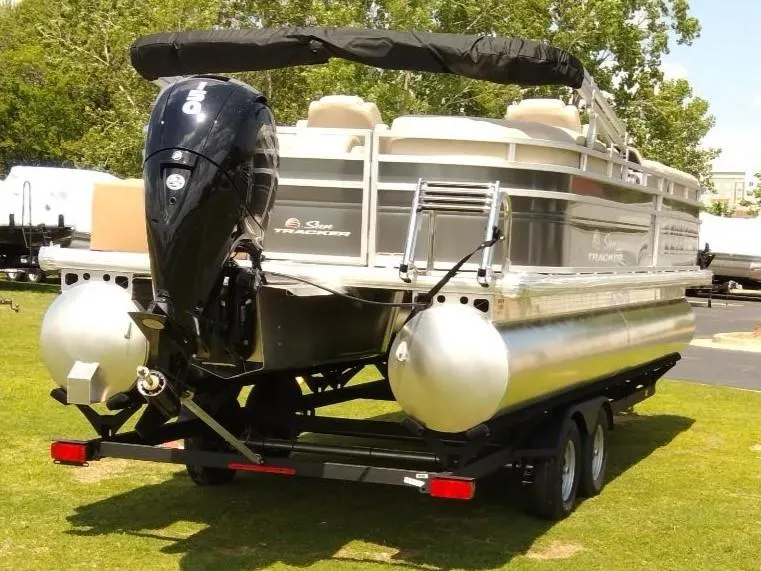 Slide: The Image of 2024 Sun Tracker Party Barge 24 DLX pontoon boat on trailer, parked on grass. - 9