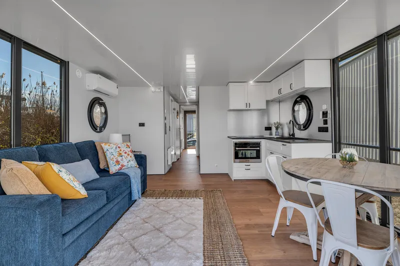 Slide: The Image of Modern Waterlodge Apart EL 2024 interior with cozy living area, kitchen, and dining space. - 17