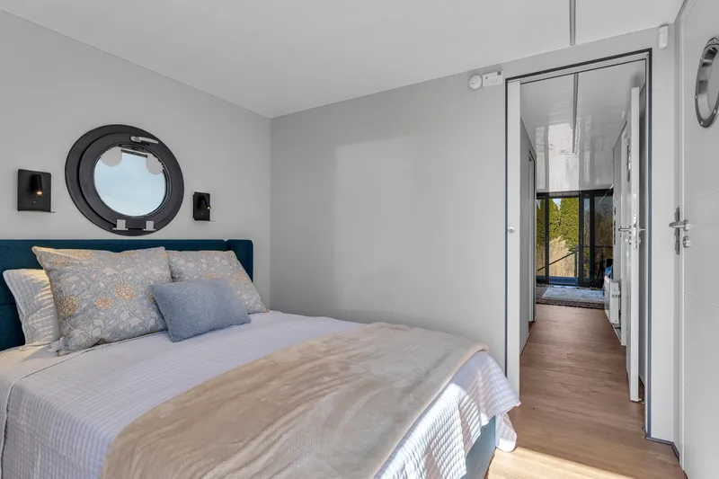 Slide: The Image of Modern bedroom in 2024 Waterlodge Apart EL with cozy bed and nautical decor. - 23