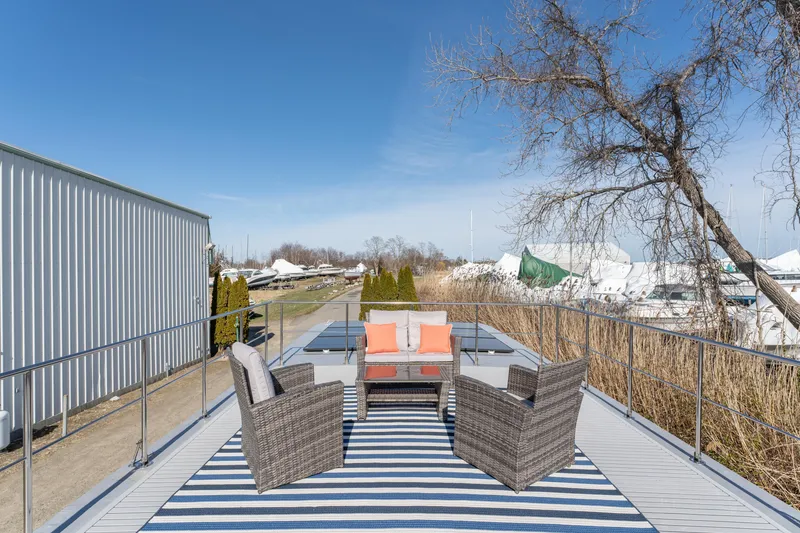 Slide: The Image of 2024 Waterlodge Apart EL rooftop deck with outdoor seating and scenic marina view. - 25
