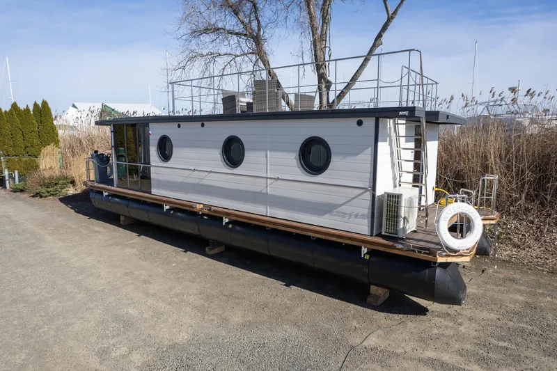 Slide: The Image of 2024 Waterlodge Apart EL houseboat with circular windows and rooftop deck. - 30