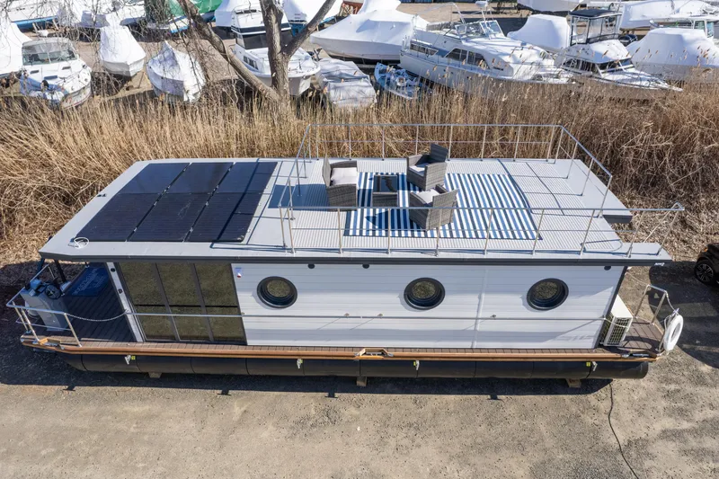 Slide: The Image of 2024 Waterlodge Apart EL houseboat with rooftop seating, docked near other boats. - 31