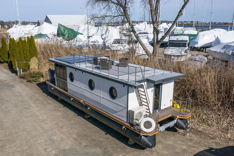 Slide: The Image of 2024 Waterlodge Apart EL houseboat docked in a marina with other boats. - 32