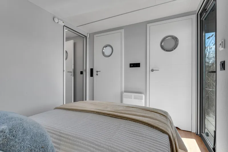 Slide: The Image of 2024 Waterlodge Apart EL bedroom with modern design and circular window details. - 5