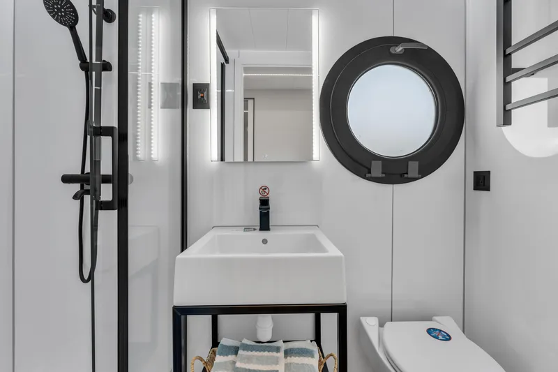 Slide: The Image of Modern bathroom in 2024 Waterlodge Apart EL with round window, shower, and sink. - 9