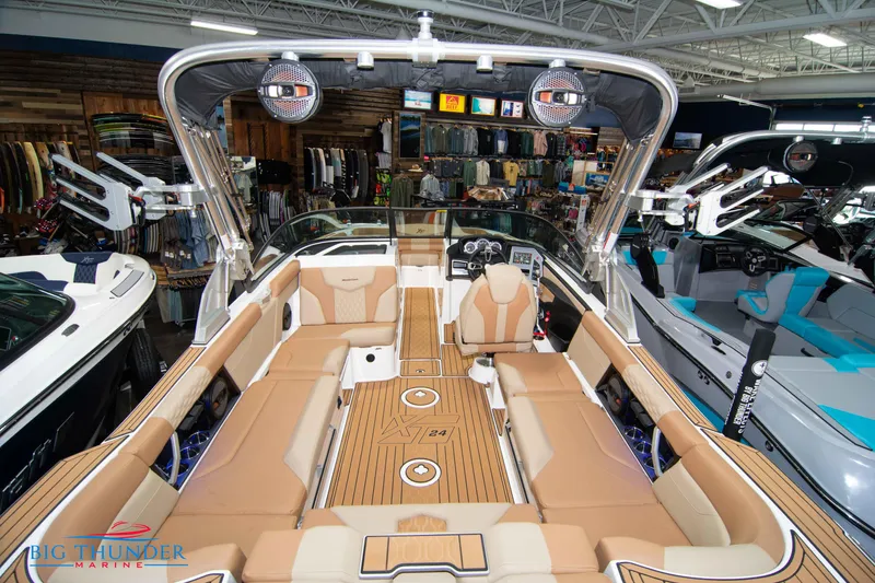 Slide: The Image of 2024 MasterCraft XT24 boat interior with tan seating and advanced audio system. - 12