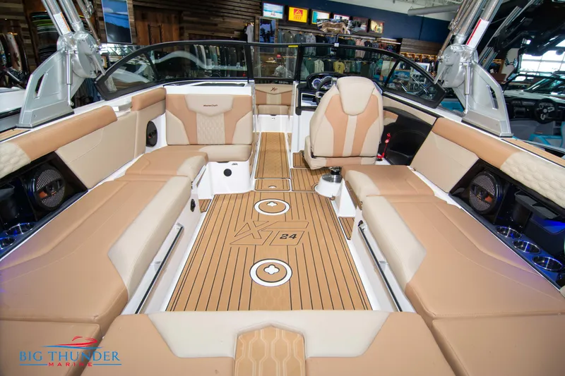 Slide: The Image of 2024 MasterCraft XT24 boat interior with tan seating and teak flooring. - 15