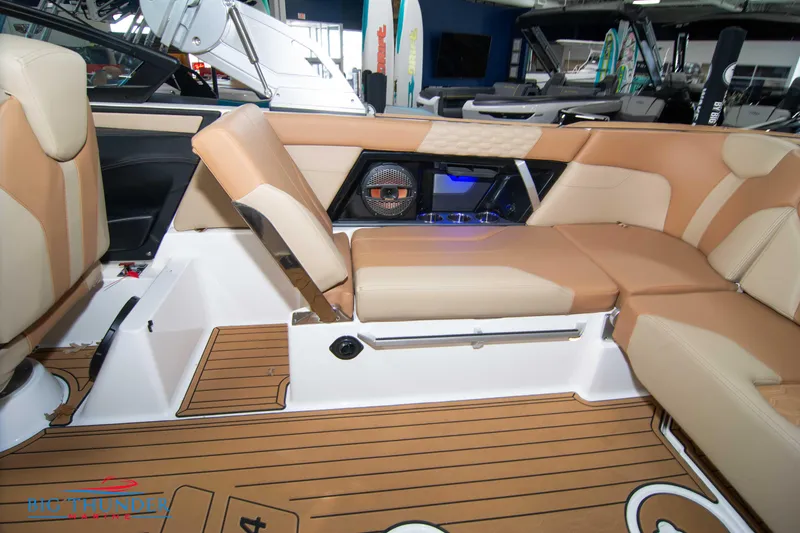 Slide: The Image of 2024 MasterCraft XT24 boat interior with tan seating and teak flooring. - 17