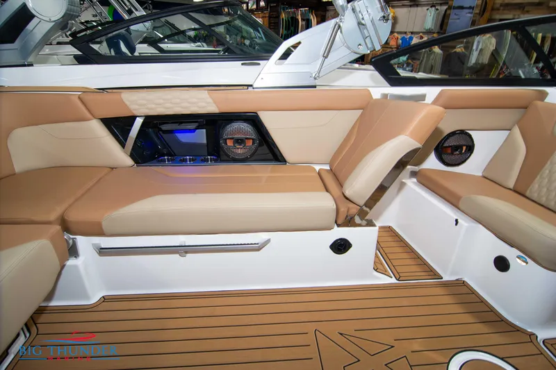 Slide: The Image of 2024 MasterCraft XT24 boat interior with tan seating and teak flooring. - 19