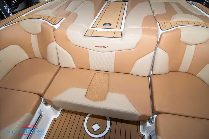Slide: The Image of 2024 MasterCraft XT24 boat interior with tan and beige seating. - 21
