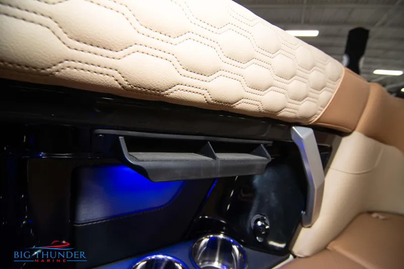 Slide: The Image of 2024 MasterCraft XT24 boat interior with beige leather seats and blue LED lighting. - 26