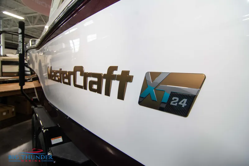 Slide: The Image of 2024 MasterCraft XT24 boat side view with logo in showroom. - 3
