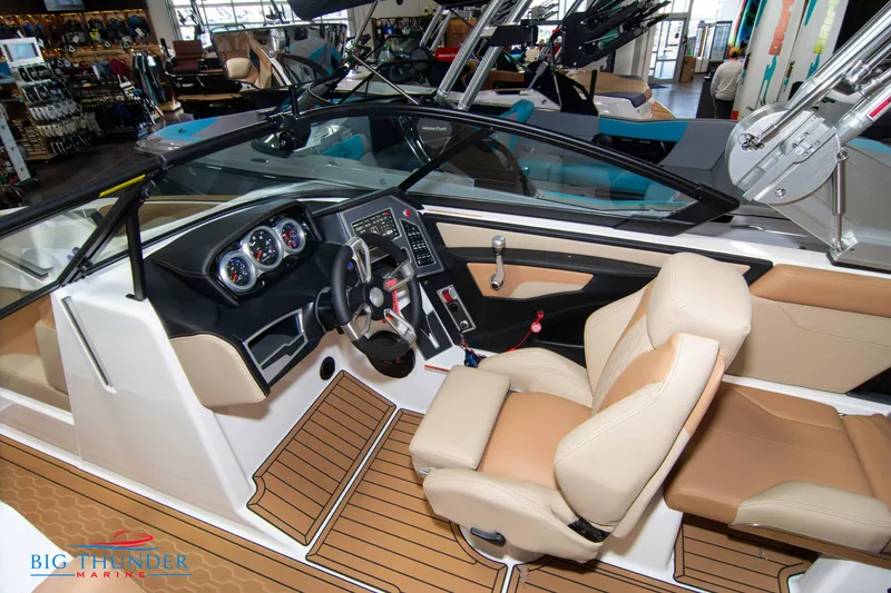 Slide: The Image of 2024 MasterCraft XT24 boat interior with tan seats and modern dashboard. - 36