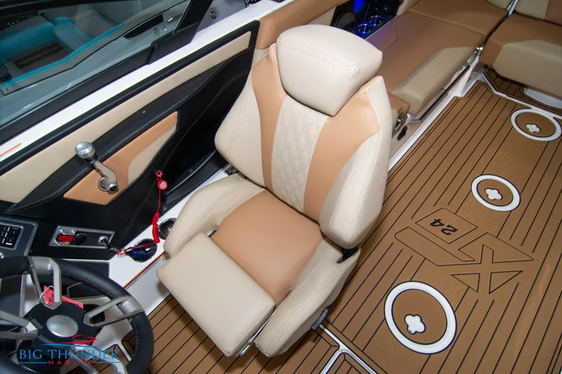 Slide: The Image of 2024 MasterCraft XT24 boat interior with tan and beige seating and wood-like flooring. - 37