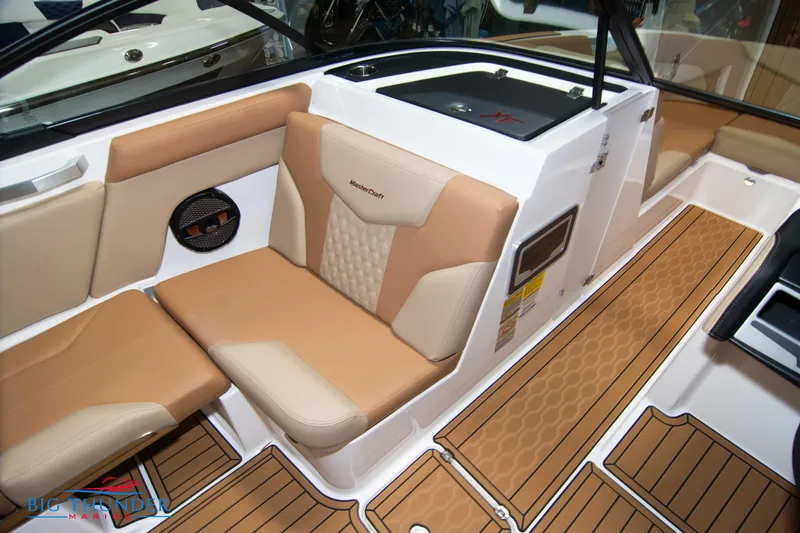Slide: The Image of 2024 MasterCraft XT24 boat interior with tan and beige seating and teak flooring. - 39