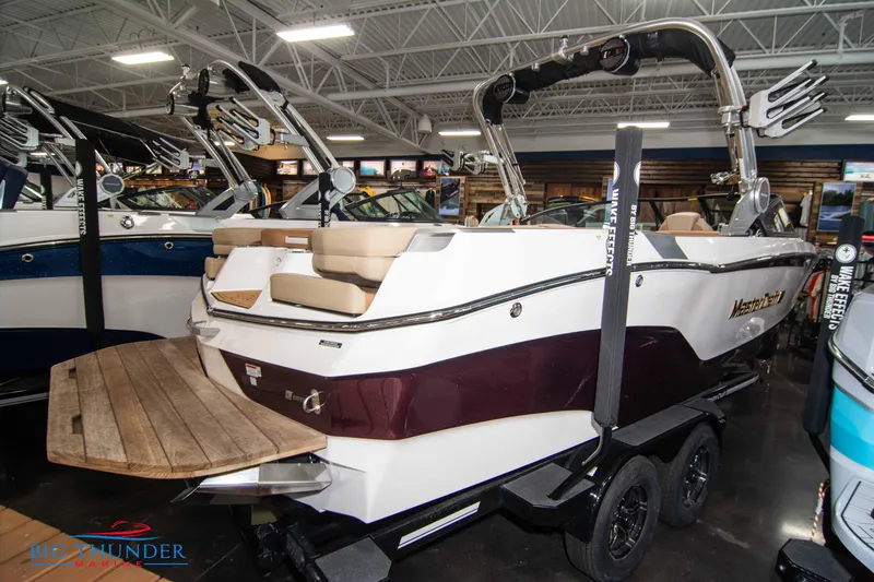 Slide: The Image of 2024 MasterCraft XT24 boat in showroom, rear view with swim platform. - 4