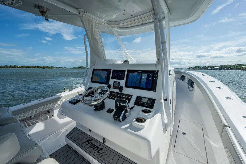 Slide: The Image of 2021 Front Runner 36 Center Console boat dashboard with navigation screens on open water. - 11