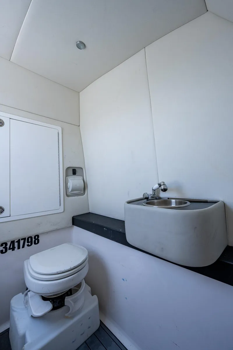 Slide: The Image of 2021 Front Runner 36 Center Console boat bathroom with toilet and sink. - 16