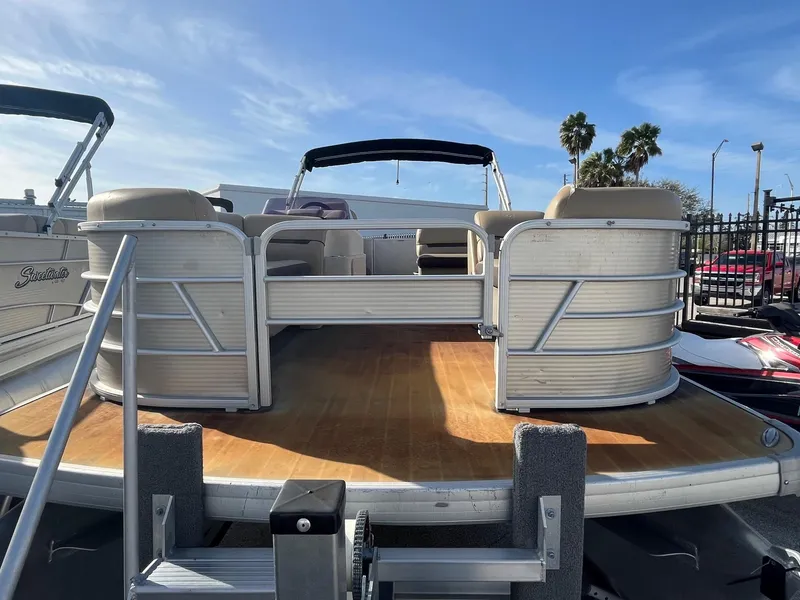 Slide: The Image of 2019 Godfrey Sweetwater 2286 pontoon boat with spacious deck and seating, under clear blue sky. - 2