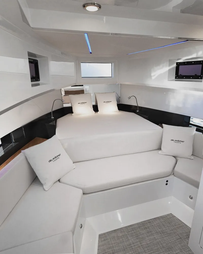 Slide: The Image of 2025 De Antonio Yachts D36 OPEN interior with modern white seating and bedding. - 10