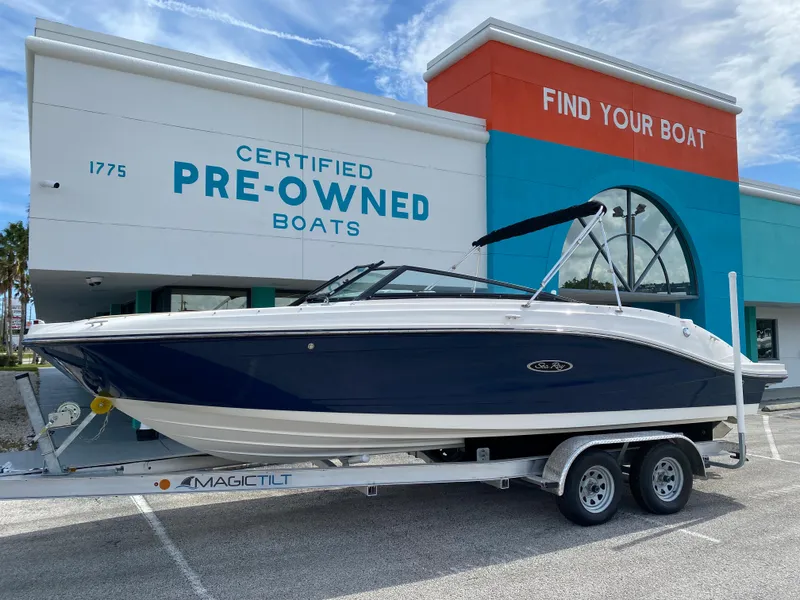 The Image of 2018 Sea Ray SLX 230 boat on a trailer outside a certified pre-owned boat dealership. - 0