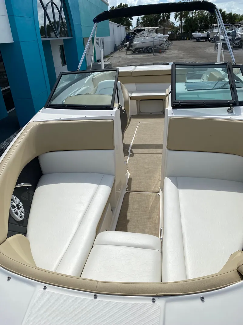 Slide: The Image of 2018 Sea Ray SLX 230 boat interior with beige and white seating. - 2
