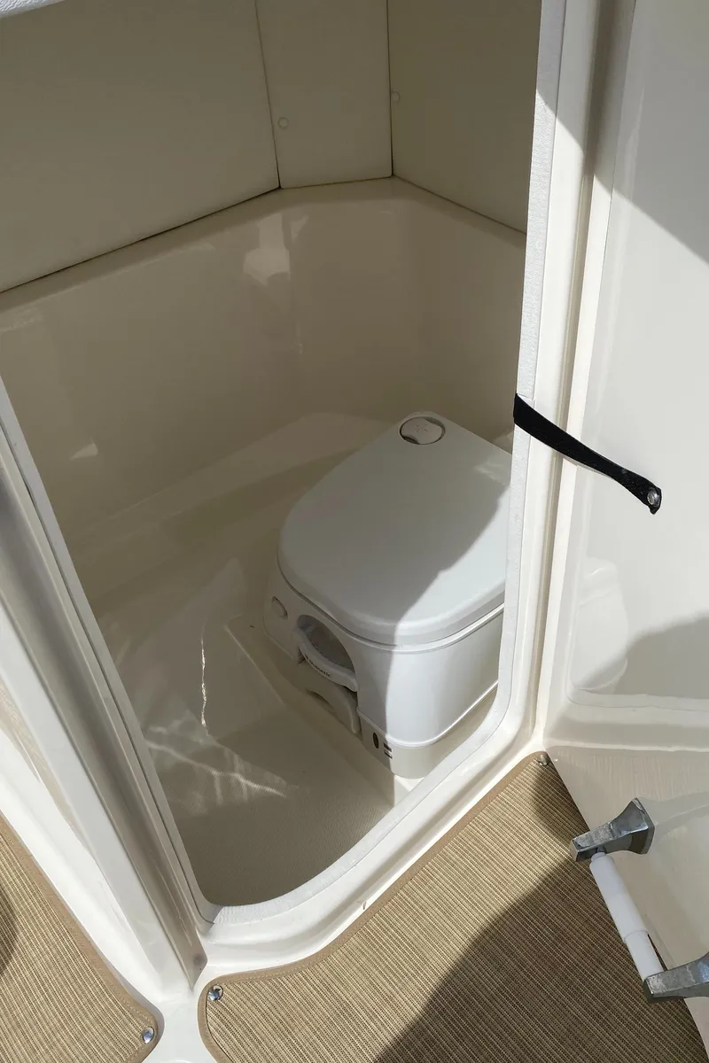 Slide: The Image of 2018 Sea Ray SLX 230 boat interior with compact marine toilet. - 9