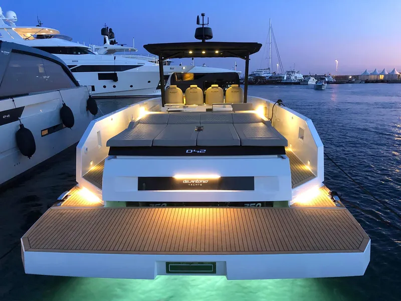 Slide: The Image of 2024 De Antonio Yachts D42 Open at dusk, illuminated deck, docked in marina. - 3
