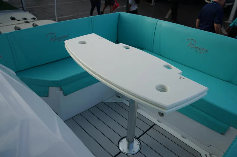 Slide: The Image of Ranieri CAYMAN 27.0 SPORT TOURING 2025 boat with teal seating and white table. - 27